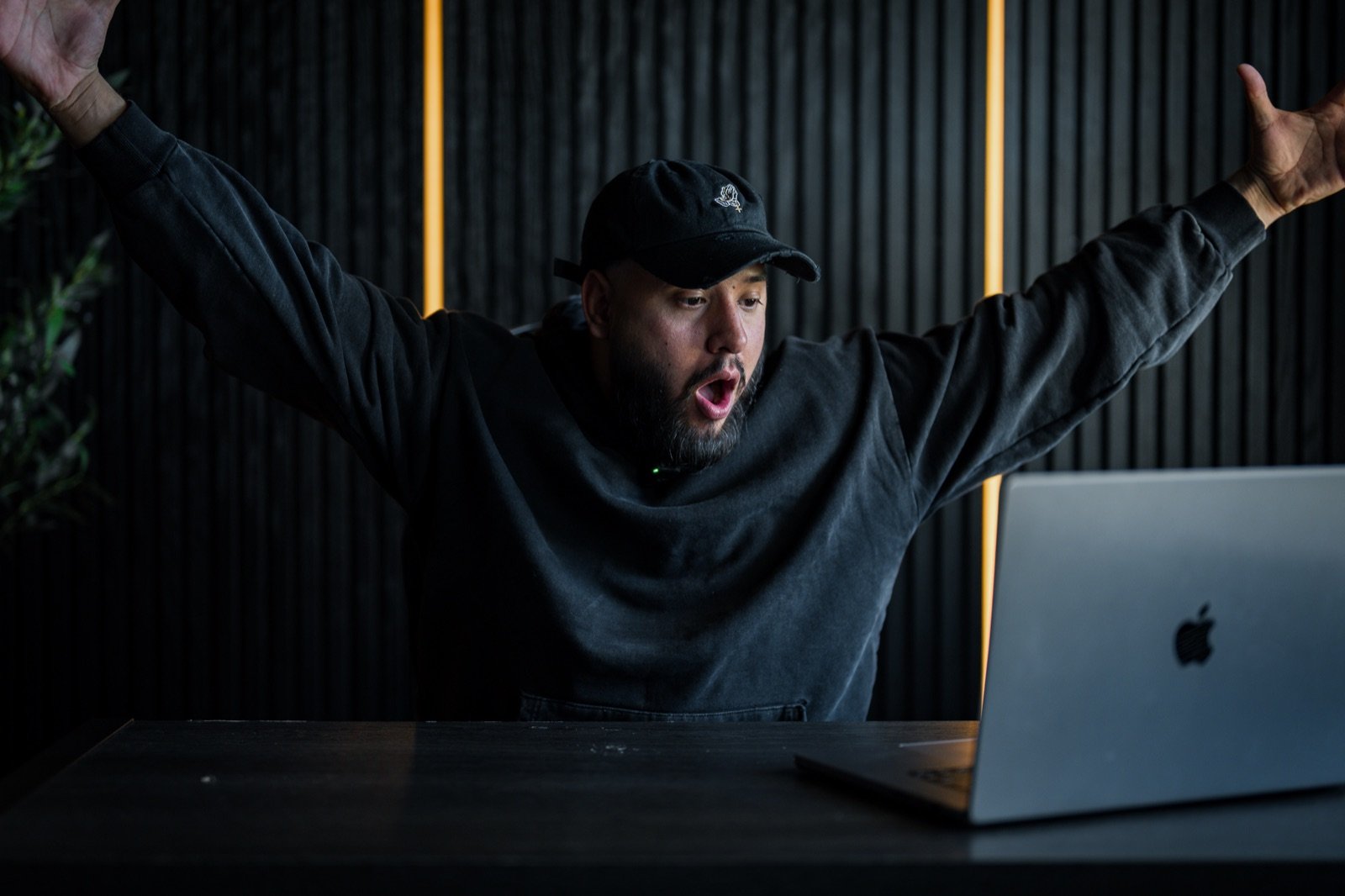 Kevin Romero with arms raised in celebration in his office