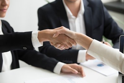 Hands shaking in a business meeting, symbolizing partnership and financial collaboration, relevant to beginner credit building and financial education for teenagers.